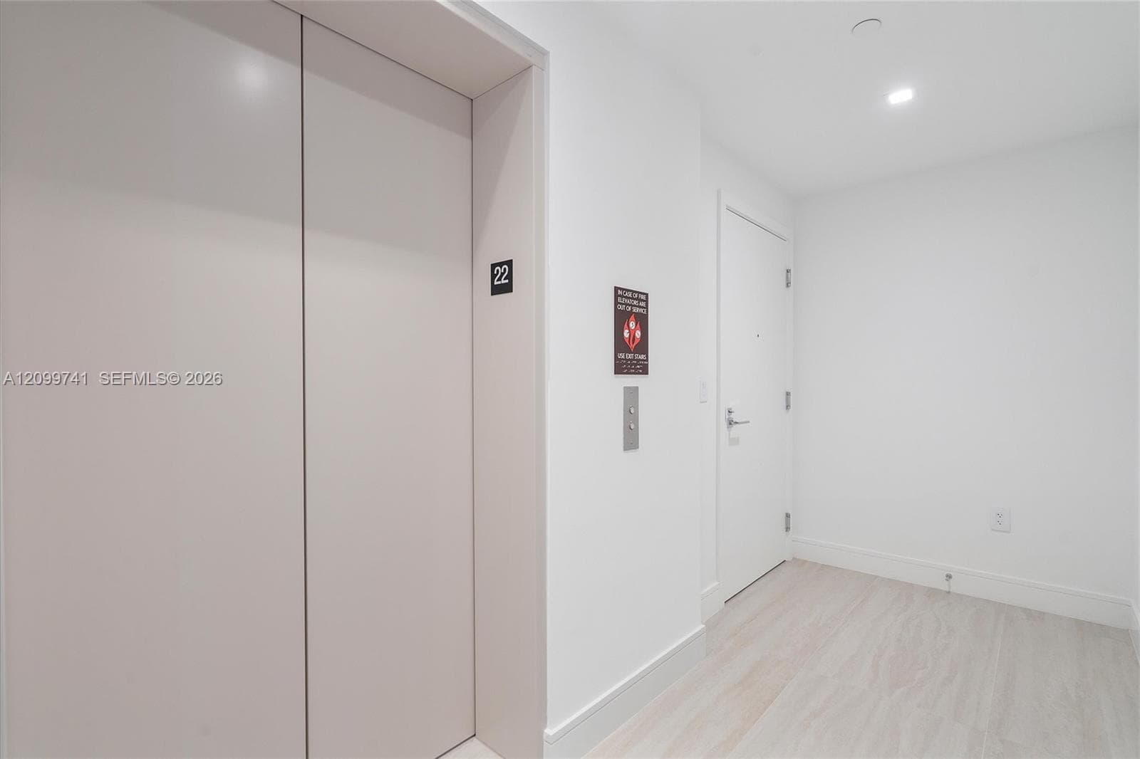 Private elevator access with direct floor entry, solid-core interior doors, recessed ceiling lighting, and light-tone wood-finish flooring