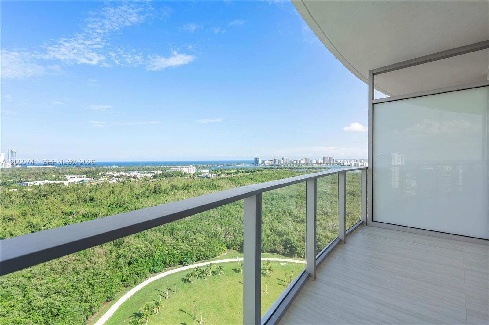 Covered balcony with neutral tile flooring, aluminum railing, and glass paneling