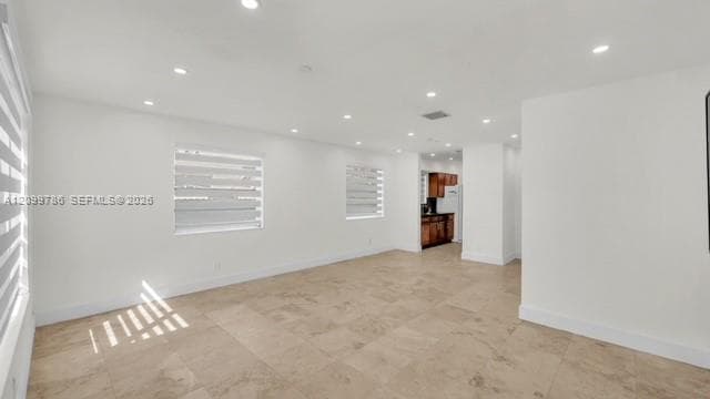 Spacious interior with recessed lighting, large format floor tiling, white walls, and multiple windows with horizontal blinds