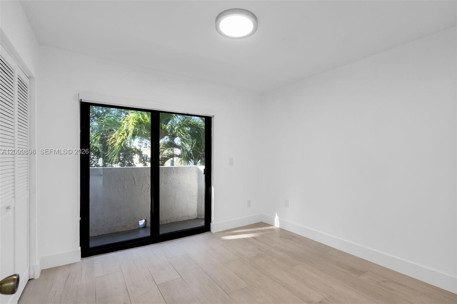 This is the view looking to the North and the second bedroom has sliding glass doors that open to a small balcony! The second floor landing and both Bedrooms and have the same tile floors.  Notice the nice Palm trees that are just off the North facing balcony.