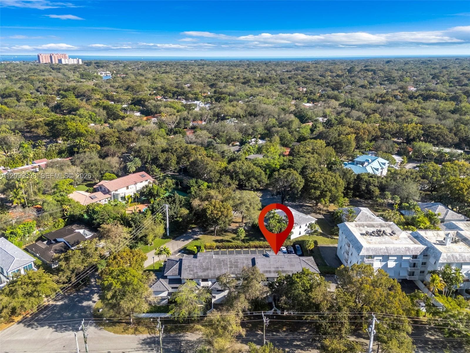 Looking South-East, this view shows the "Gables South Condo Building" and that exact location of Unit 206 and that the Primary Bedroom faces South-East which overlooks a quiet residential family neighborhood! The dark blue you see over the tree line is Biscayne Bay and Matheson Hammock Beach, that is a wonderful Beach & only a 2 mile BICYCLE RIDE" away from your Townhouse!!