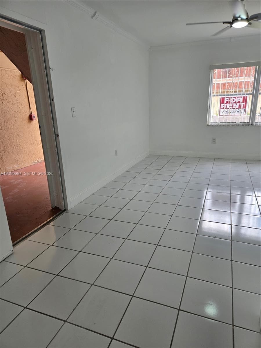 Ceramic tile flooring, white walls, and a ceiling fan with integrated lighting