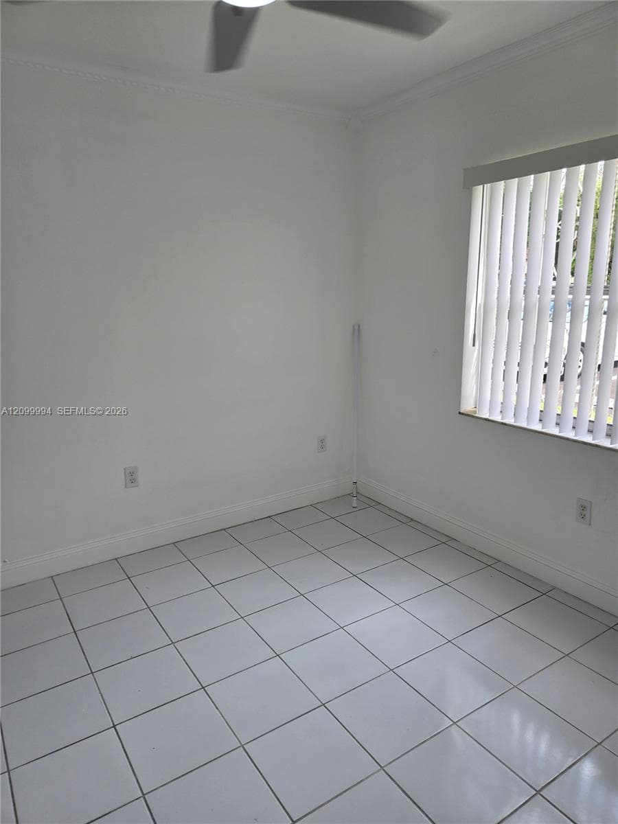 Neutral-toned ceramic tile flooring, ceiling fan, and window featuring vertical blinds
