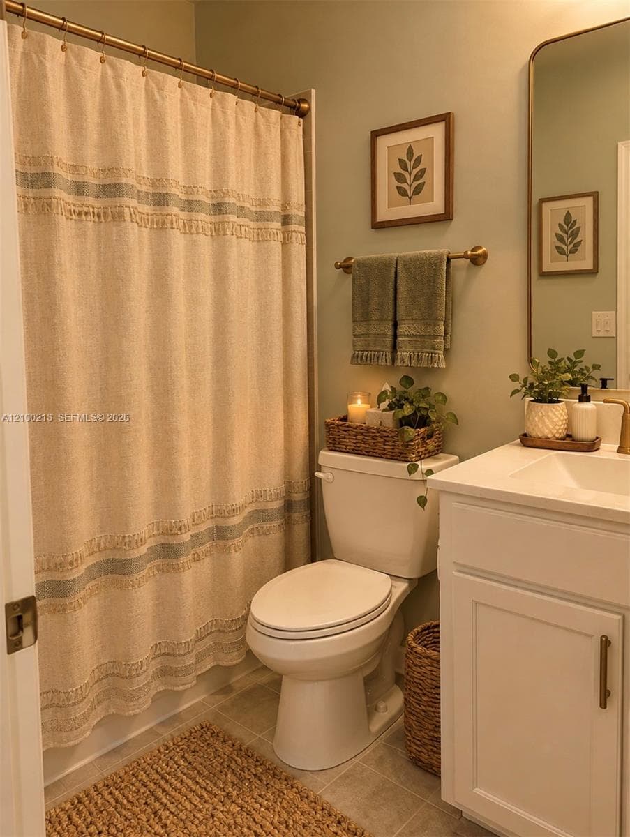 Bathroom featuring a white vanity cabinet with a integrated sink, metallic hardware, an arched wall mirror, and a wall-mounted metallic towel bar