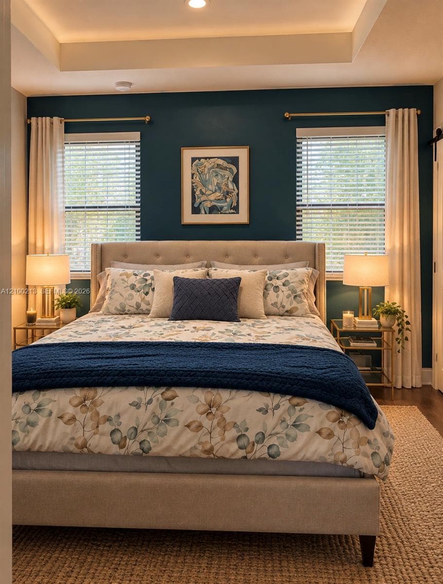 Tray ceiling with recessed lighting, deep blue accent wall, dual windows with horizontal blinds, and dark wood-finish flooring