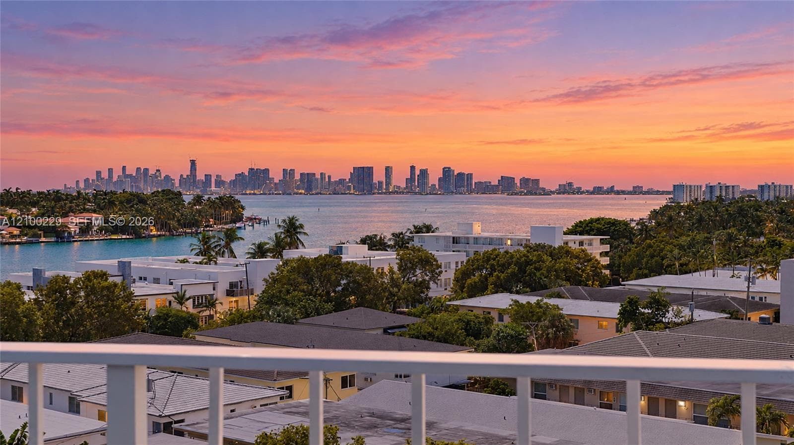 Elevated balcony featuring a white metal railing with expansive coastal and skyline scenery
