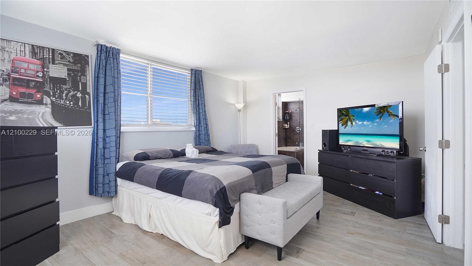 Bedroom featuring wood-finish flooring and a multi-pane window