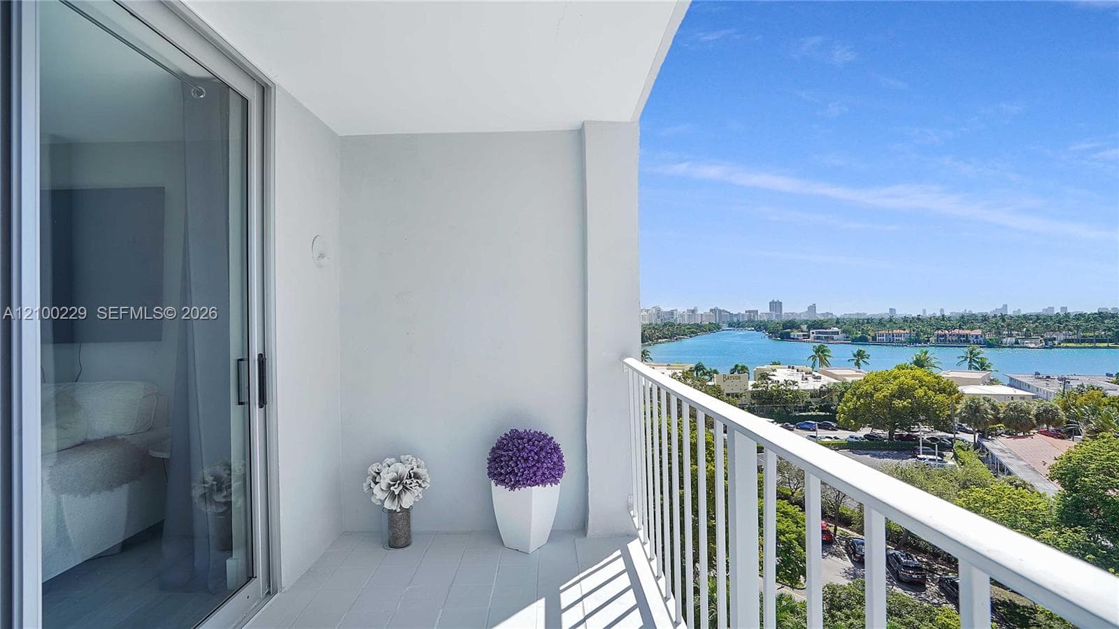 Covered balcony featuring a white metal railing, neutral tile flooring, and sliding glass door access