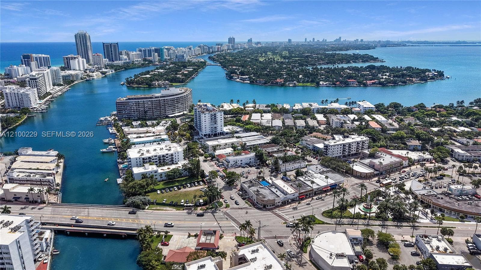 Aerial perspective featuring an expansive urban waterway, coastal shoreline, bridge infrastructure, and dense metropolitan cityscape