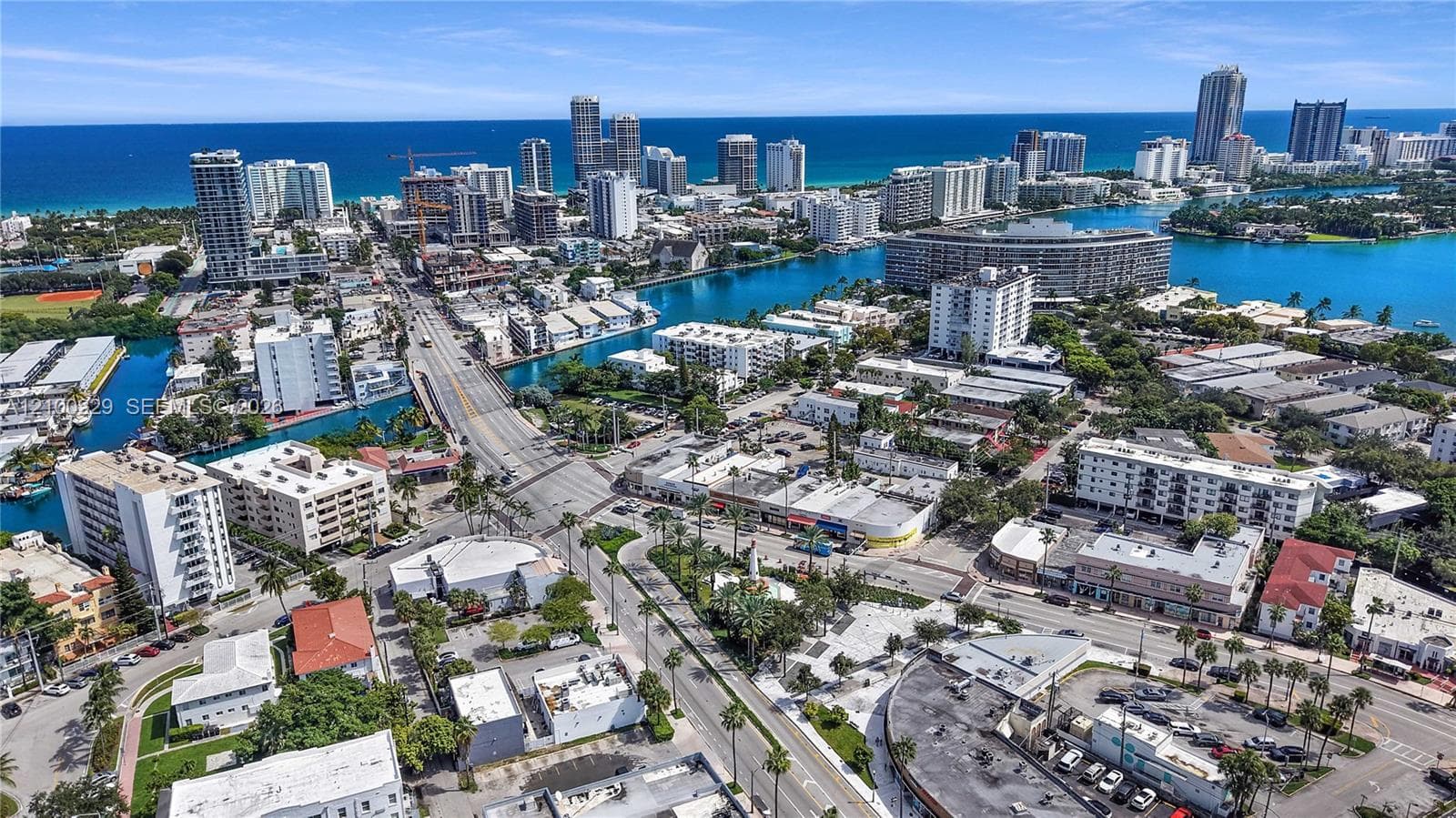 Aerial perspective of a coastal urban landscape featuring multi-story high-rise buildings, waterways, and proximity to the coastline