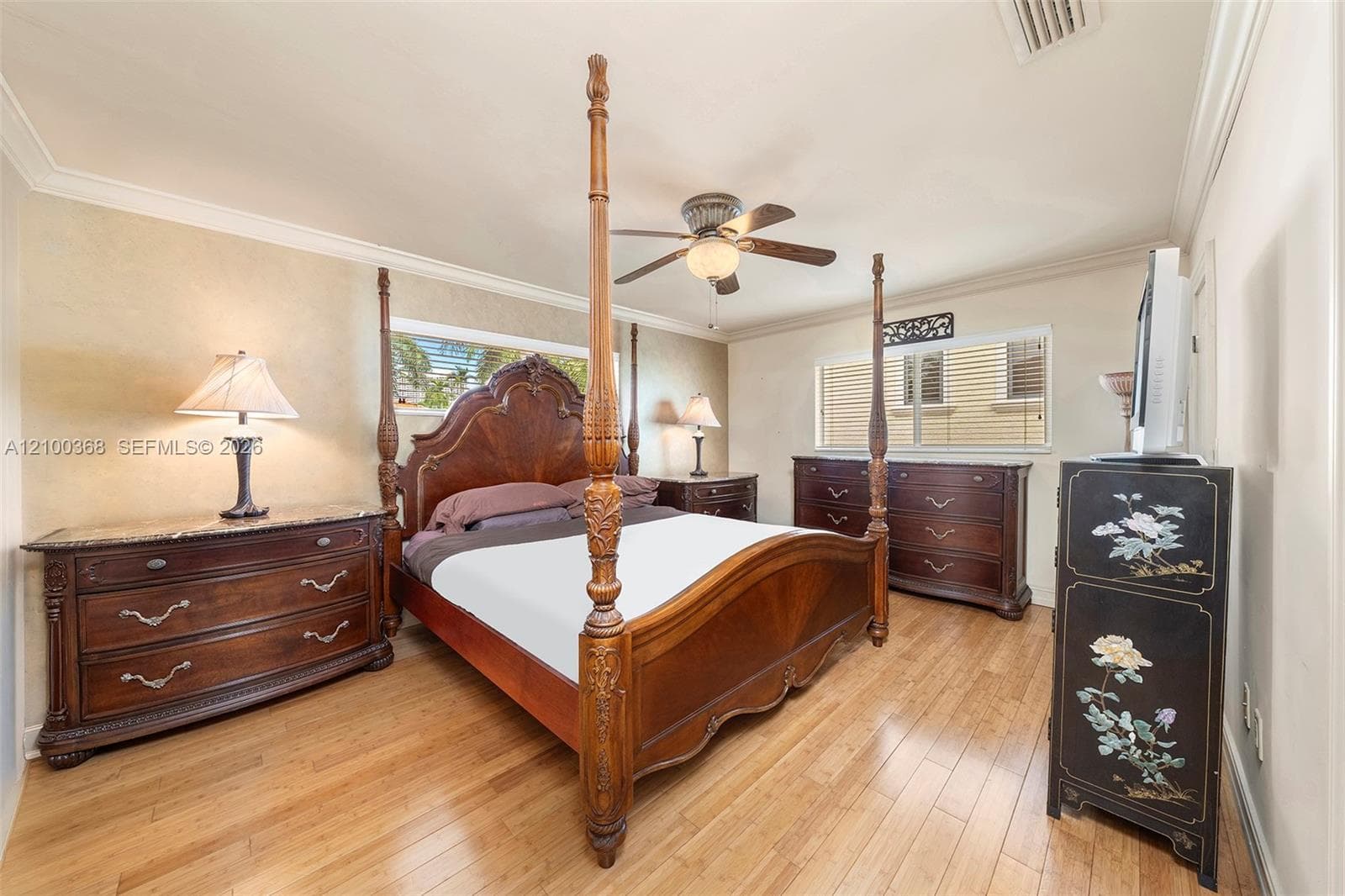Wood-finish flooring, crown molding, and ceiling fan with integrated lighting