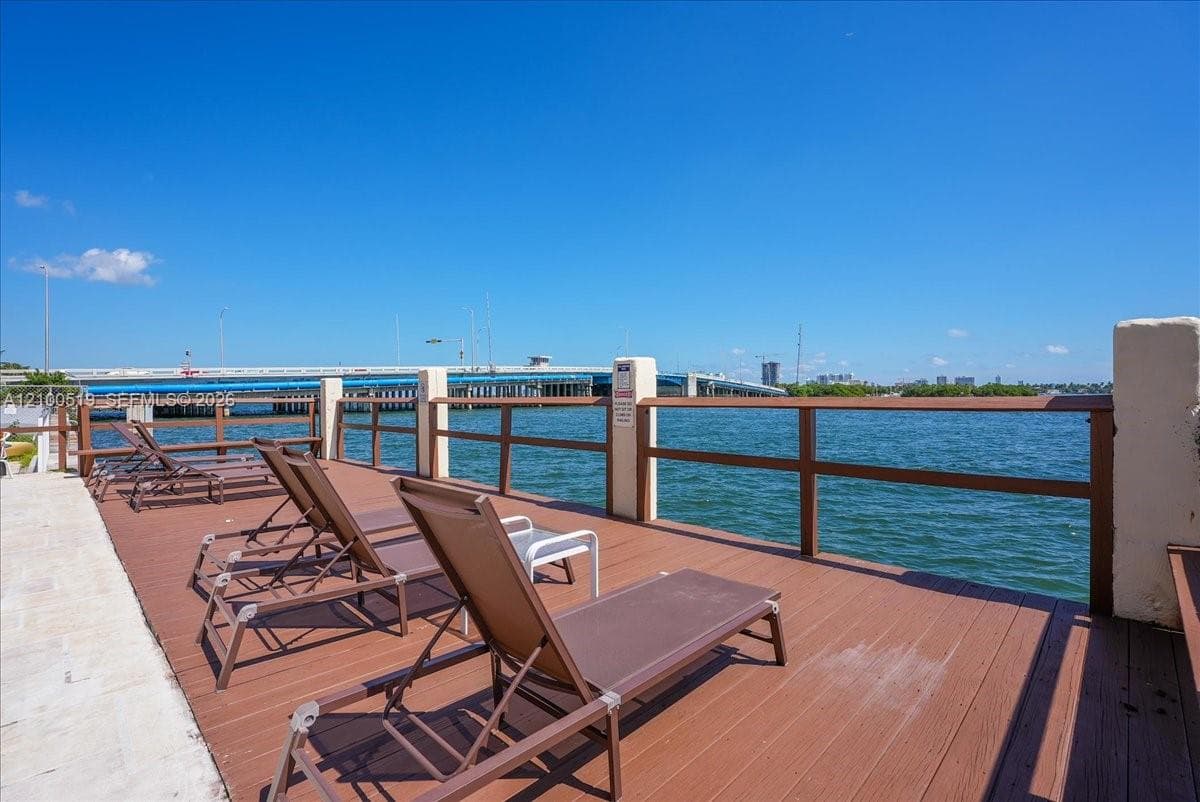Waterfront deck featuring wood-finish decking and a wooden post-and-rail perimeter