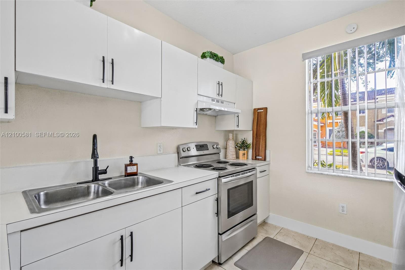 Neutral-toned interior featuring large-format polished tile flooring, white panel doors with modern hardware, and a wall-mounted electrical service panel