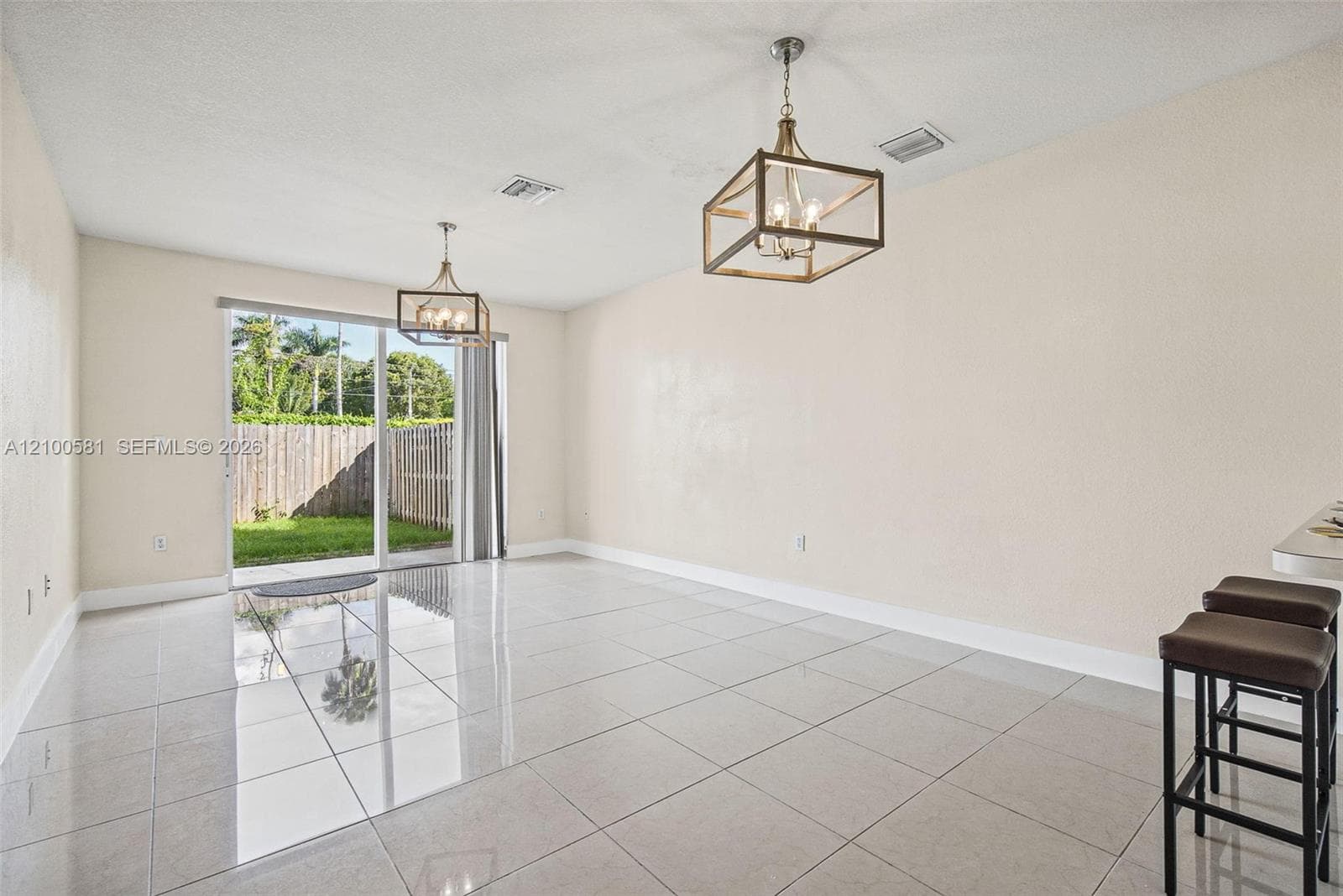 Interior entryway featuring arched architectural openings, ceramic tile flooring, a white six-panel door, and white shaker-style cabinetry with a built-in breakfast bar