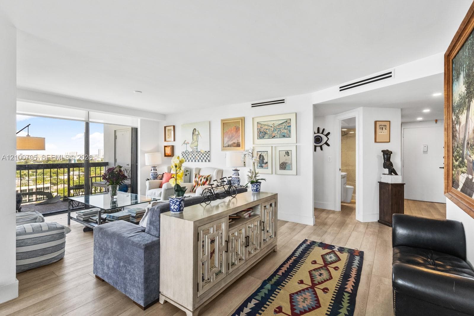 Living area featuring wood-finish flooring, floor-to-ceiling windows, and recessed lighting
