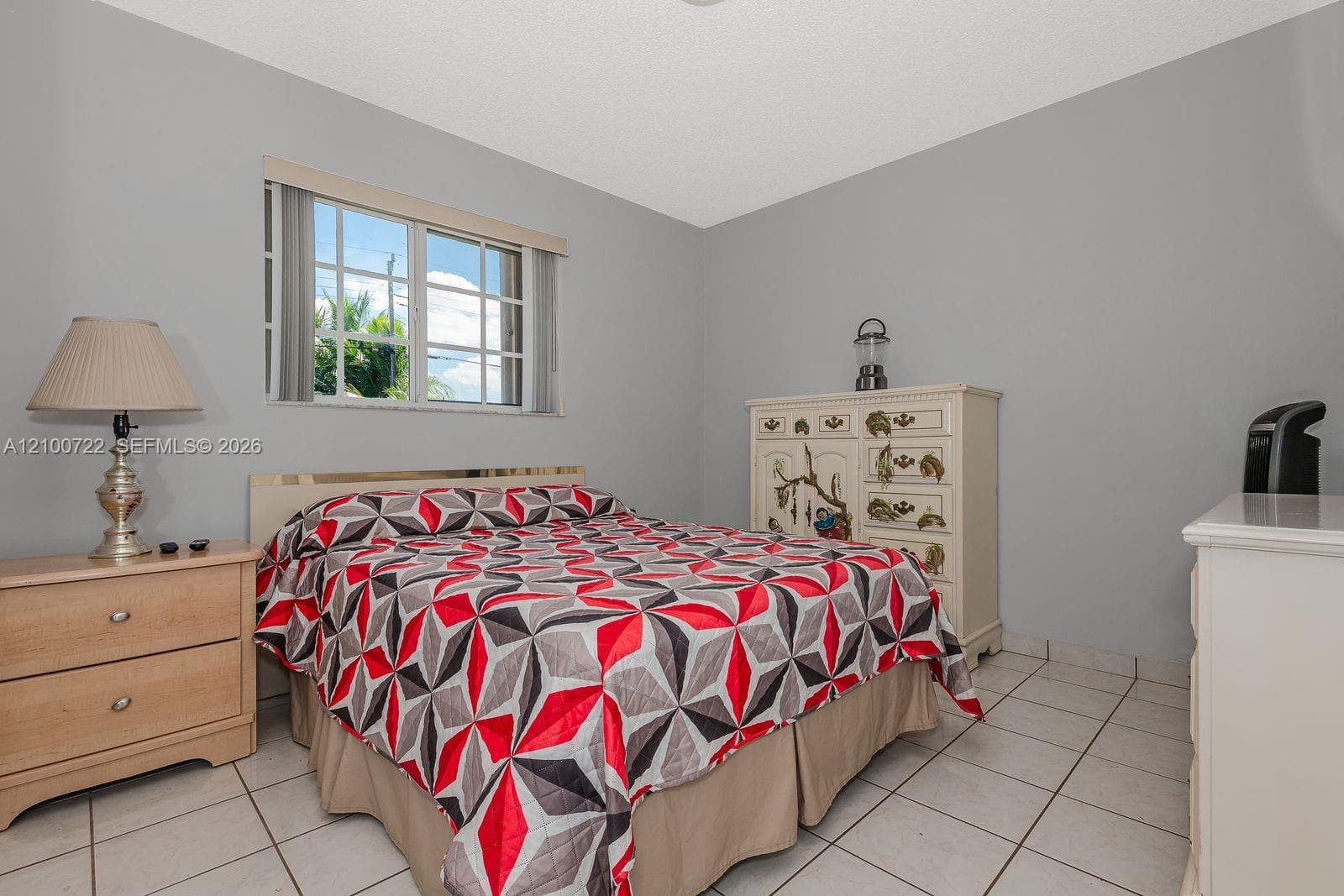 Neutral wall palette featuring single-pane window with grid muntins and tile flooring