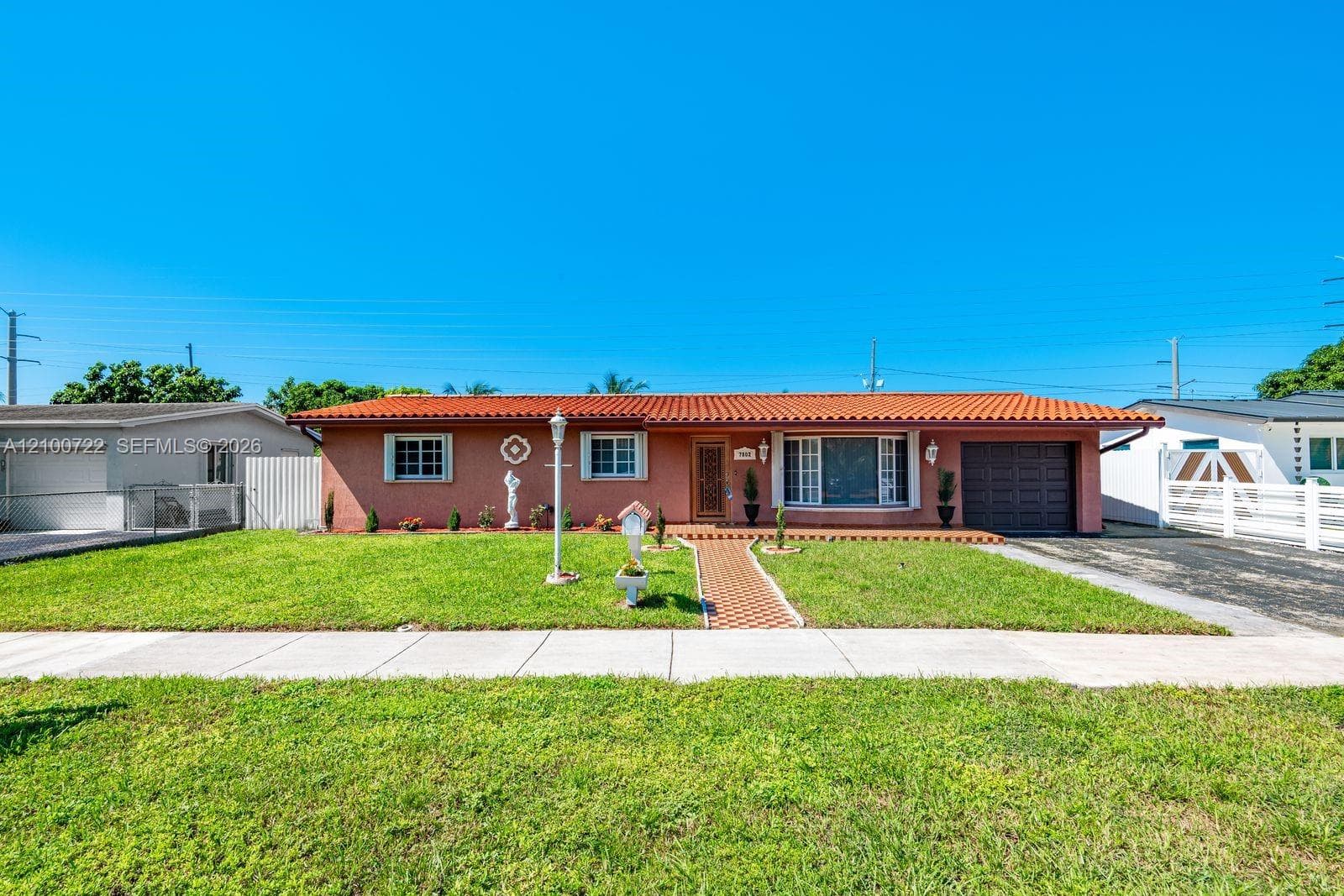 Single-story residence featuring a tile roof, stucco exterior, integrated one-car garage, and brick-paver walkway