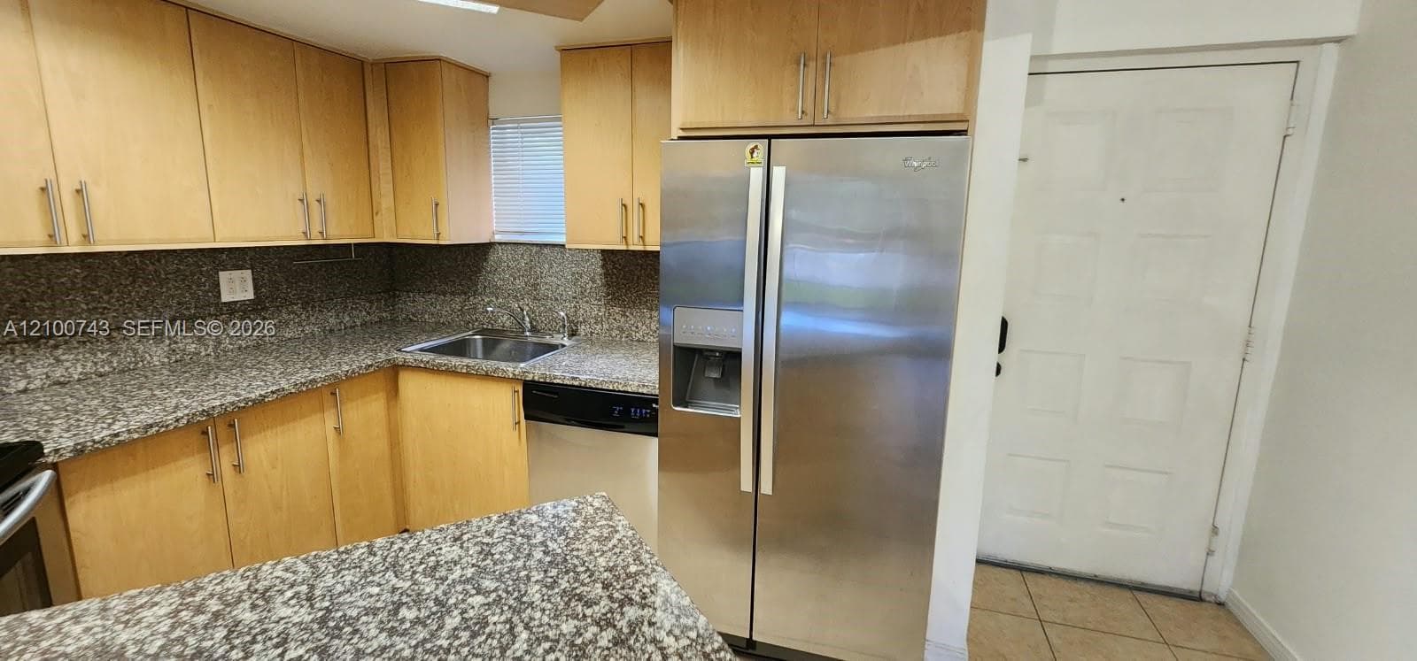 Kitchen featuring light wood cabinetry, stone-finish countertops, a double-door stainless steel refrigerator, and tiled flooring