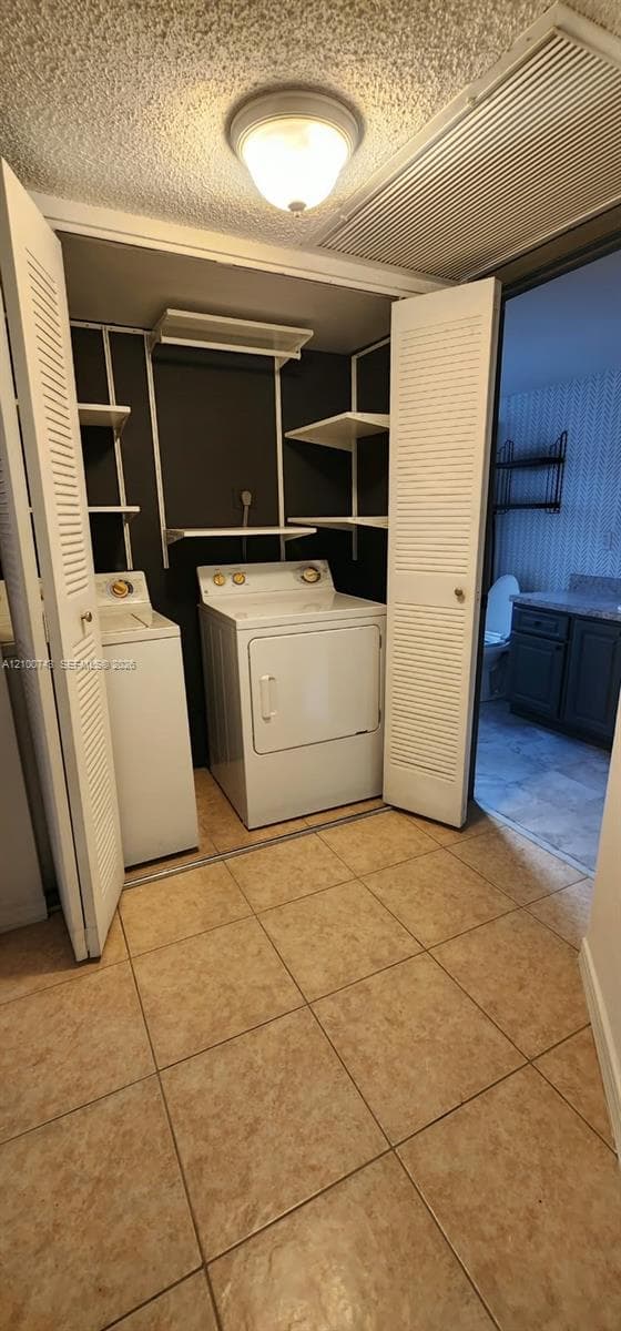 Laundry area featuring tile flooring, louvered bi-fold doors, and built-in shelving