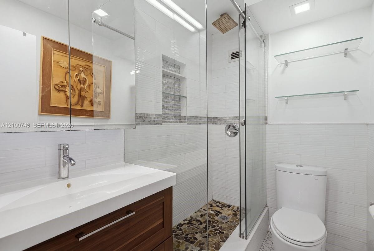 Neutral-toned interior space featuring light-colored diagonal floor tile and a brushed-nickel ceiling fan with integrated lighting