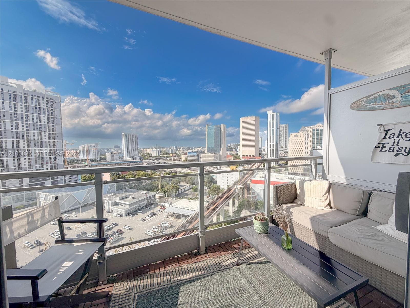Private balcony featuring glass panel railing and panoramic city skyline backdrop