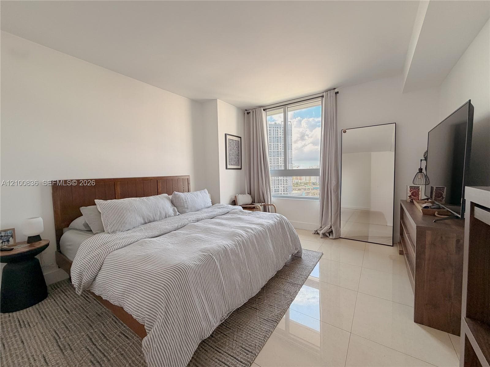 Floor-to-ceiling window featuring urban exterior scenery and polished large-format tile flooring