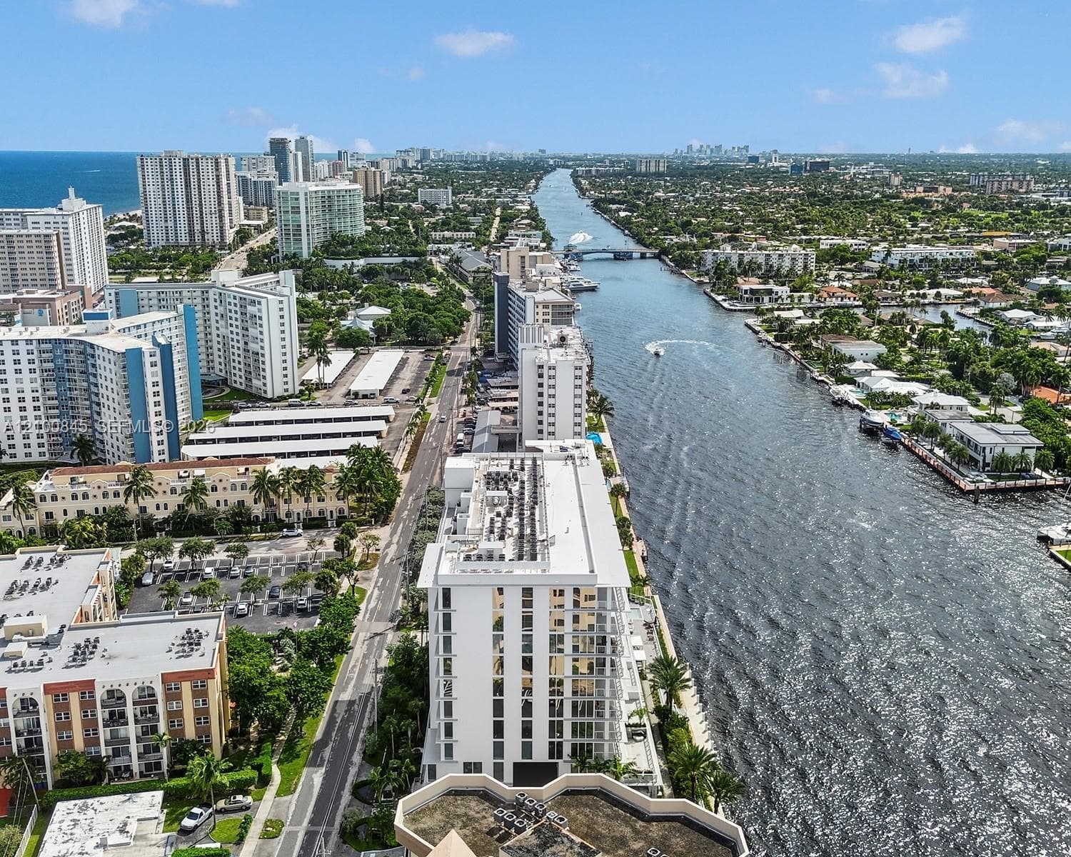 Aerial perspective of coastal landscape featuring deep-water waterway access, proximity to oceanfront high-rises, and established waterfront urban infrastructure