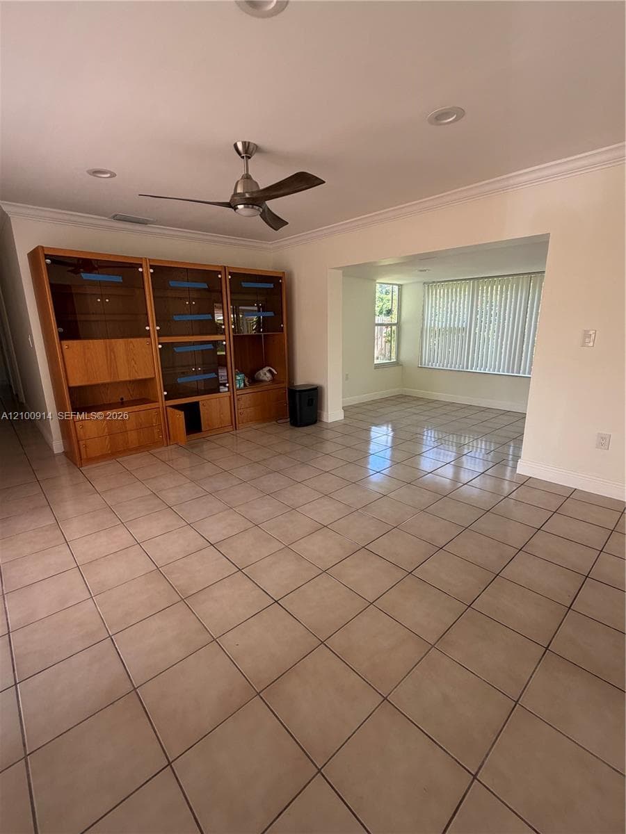 Ceramic tile flooring, recessed lighting, crown molding, and a ceiling fan