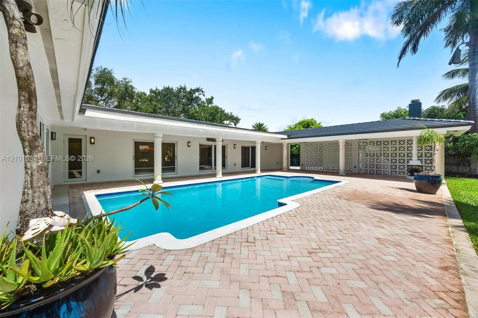Surrounded by lush greenery and connected to the outdoor living areas, the pool feels like a private retreat right at home.