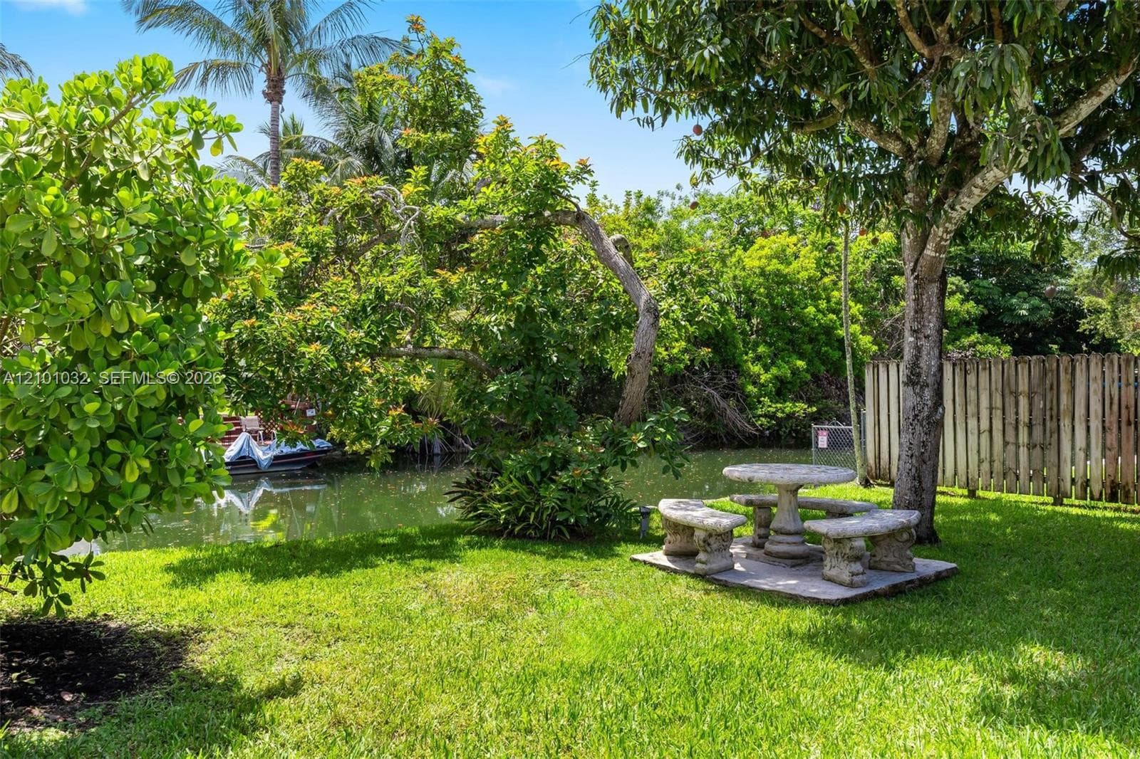 A spacious backyard surrounded by lush tropical landscaping and mature fruit trees, with plenty of room to spend the day outdoors.