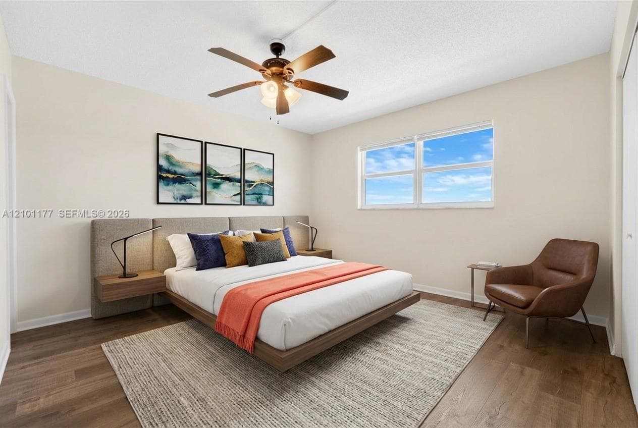 Neutral-toned interior featuring wood-finish flooring, a multi-pane horizontal window, and a ceiling fan with integrated lighting