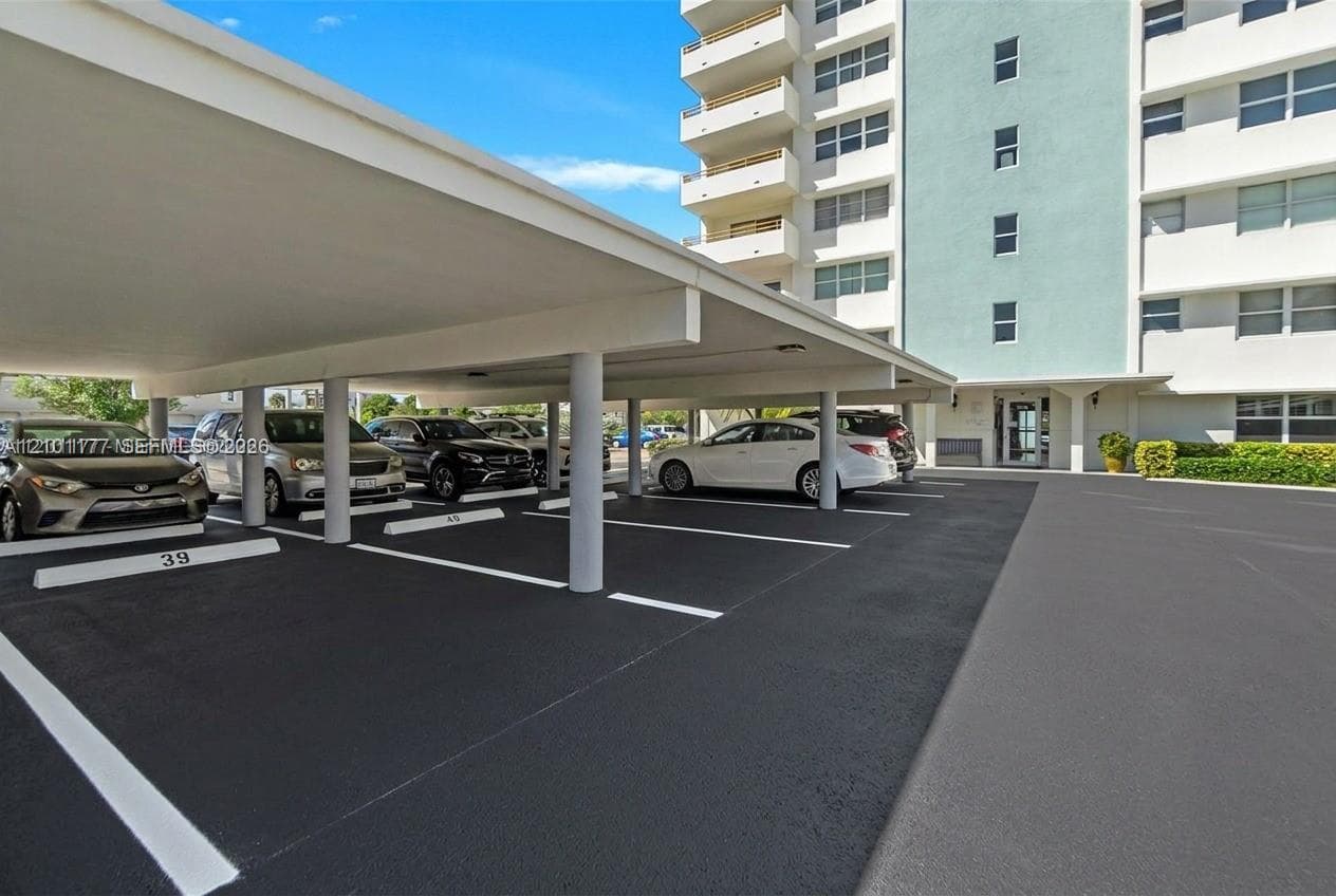 Covered parking structure with individual stalls and concrete support pillars