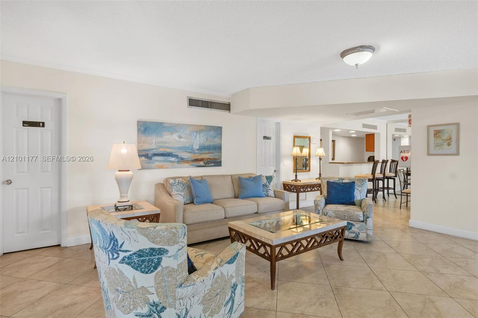 Neutral-tone tile flooring, flush-mount ceiling lighting, and arched architectural soffit