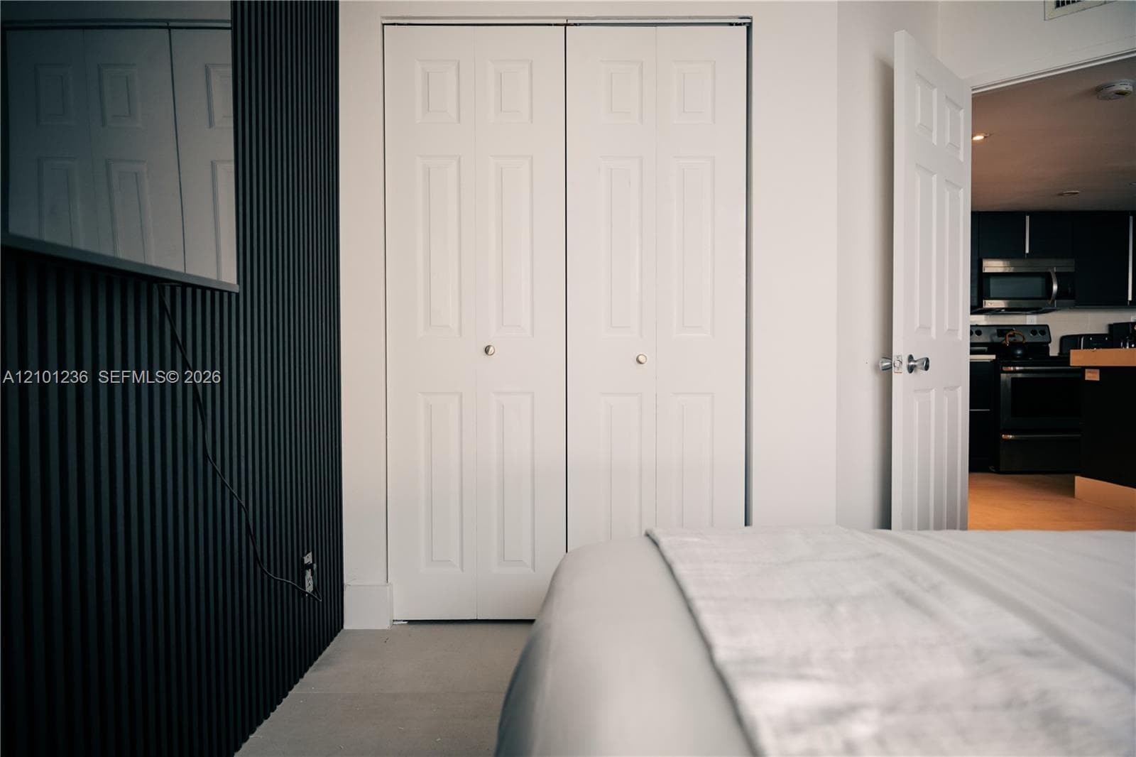 Black vertical slat accent wall and white six-panel bi-fold closet doors