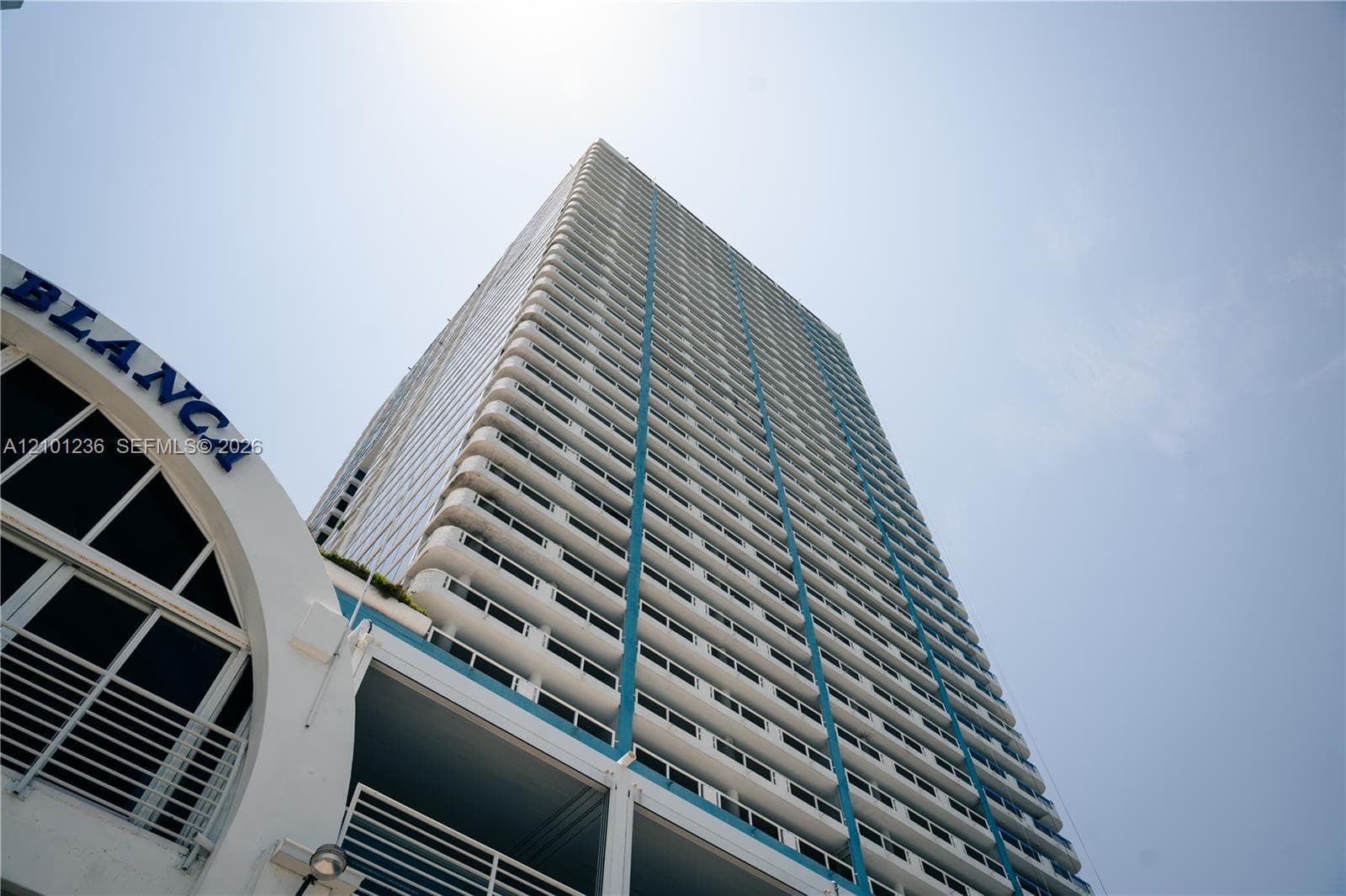 High-rise residential tower featuring multiple private balconies, vertical architectural accents, and arched structural design elements