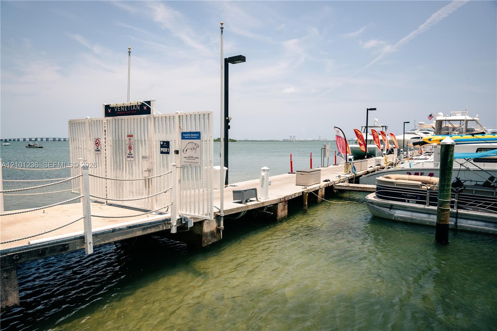 Concrete deep-water dock featuring metal security gates, integrated lighting fixtures, and nautical rope railing