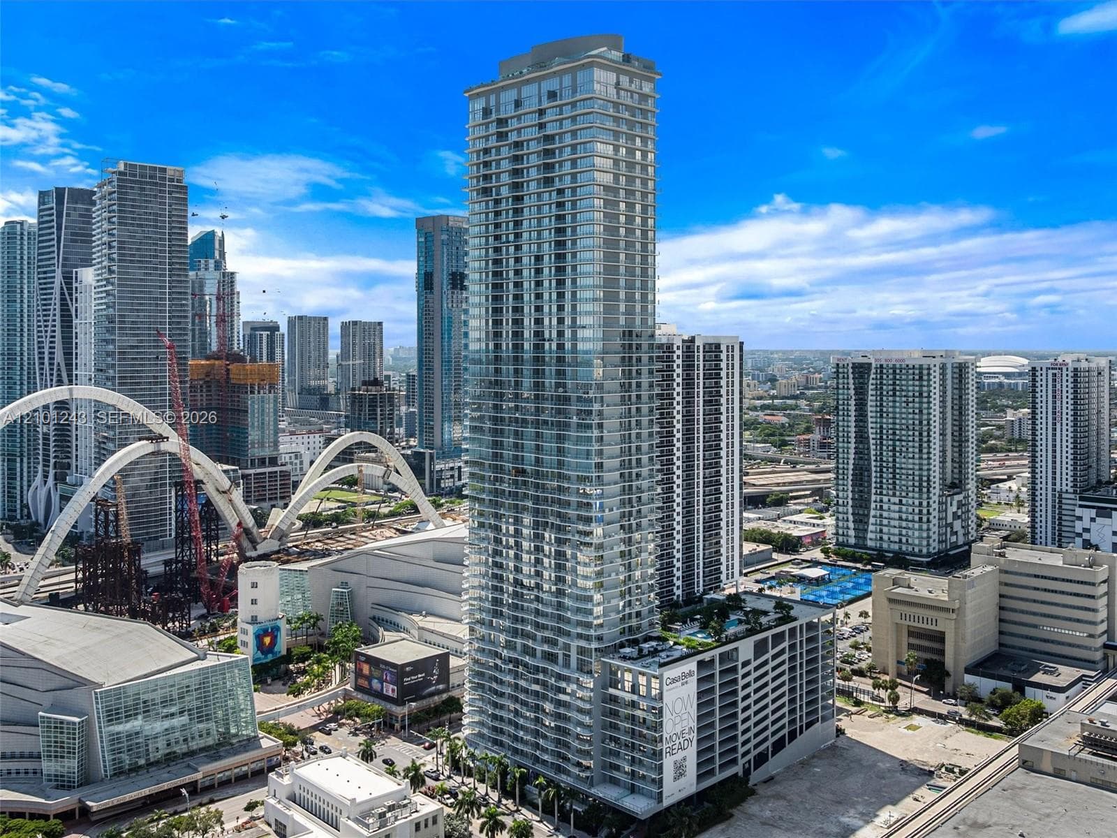 High-rise architectural tower featuring floor-to-ceiling glass paneling, a multi-level structure, private balconies, and an elevated outdoor deck