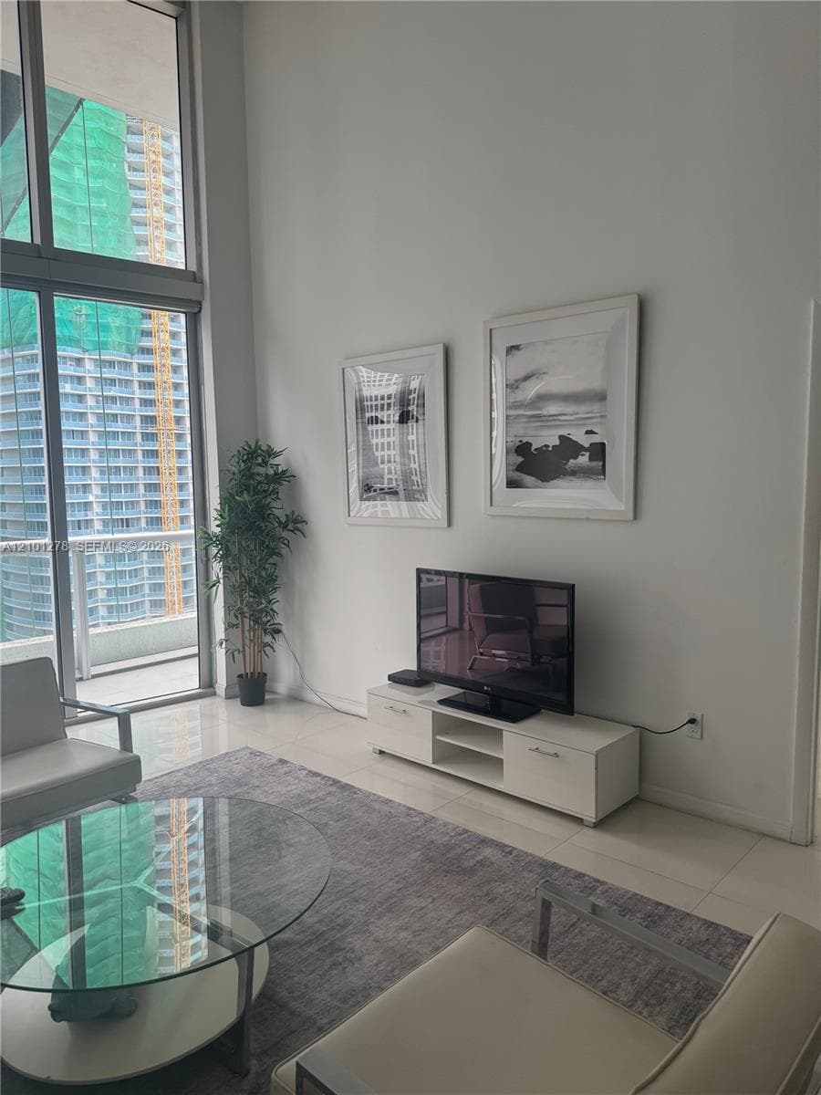 Floor-to-ceiling windows, high ceilings, and large-format tile flooring