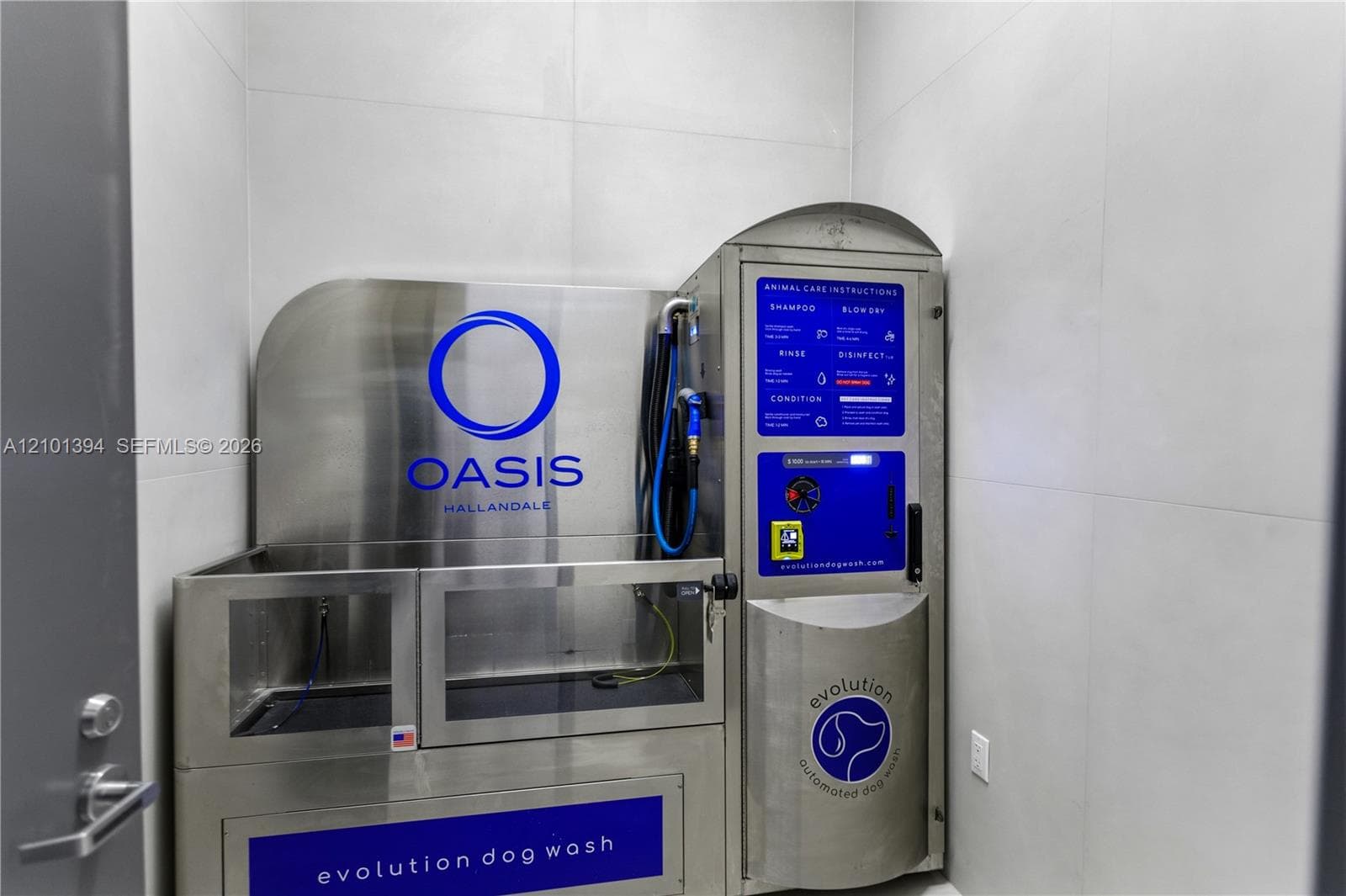 Automated stainless steel wash station featuring integrated rinsing and drying controls, set against large-format neutral wall tile