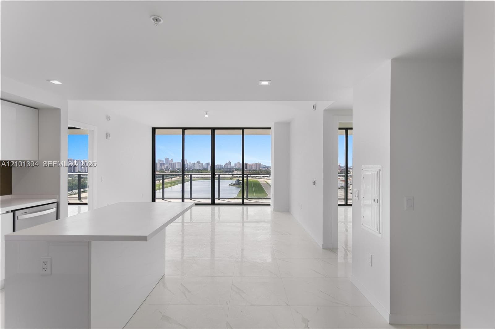 Open-concept interior featuring large-format tile flooring, recessed lighting, and a kitchen island with a quartz countertop