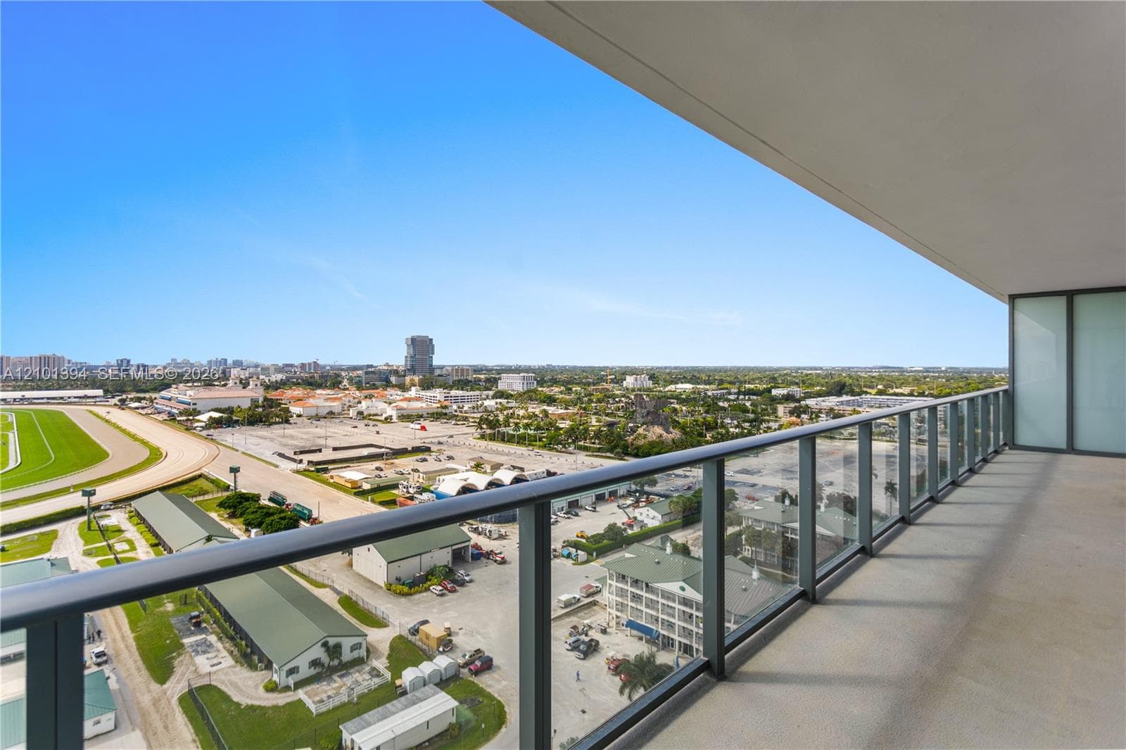 Covered balcony featuring concrete flooring and a full-length glass railing