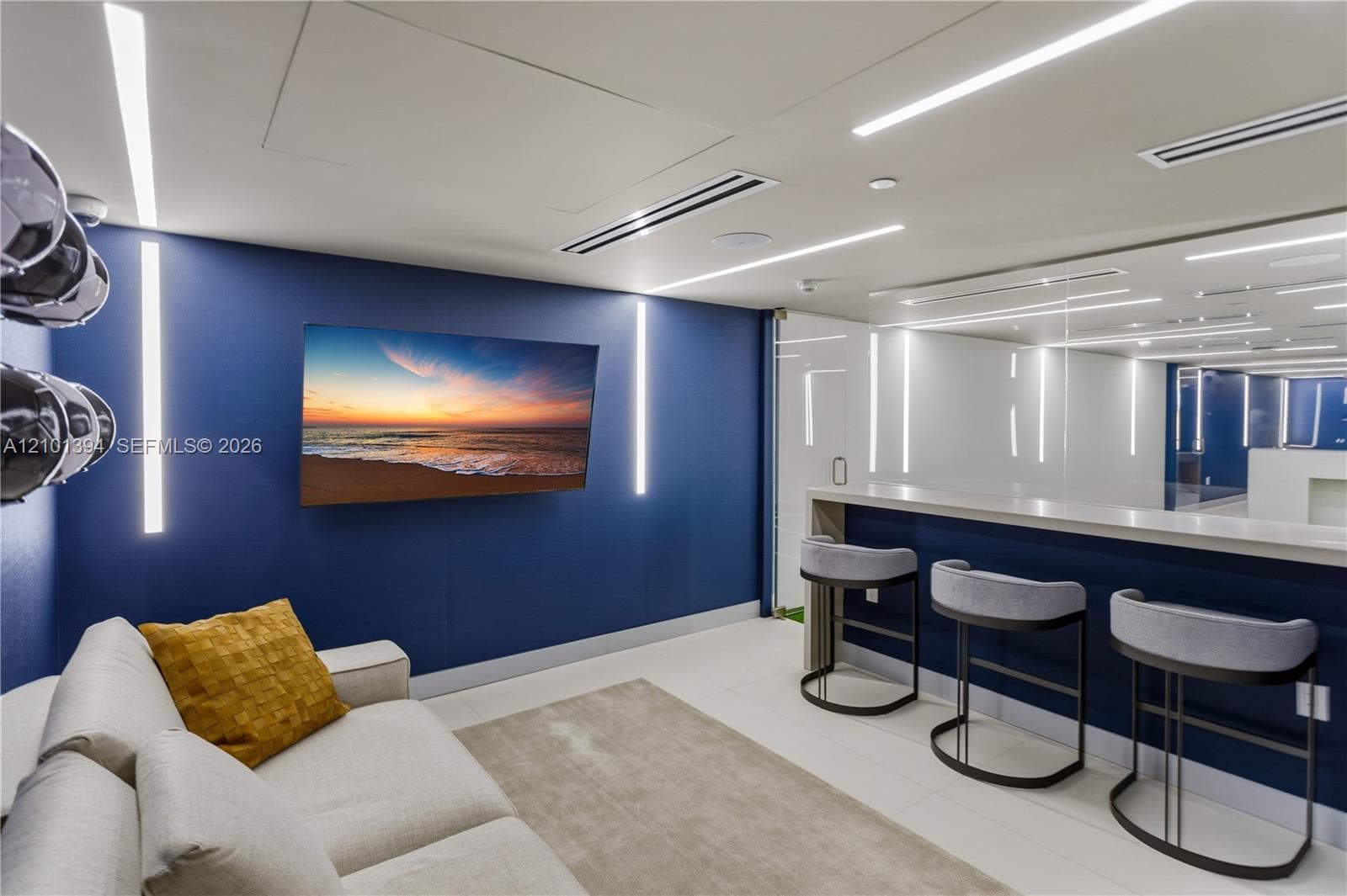 Custom interior featuring a built-in refreshment bar with a solid surface countertop, linear LED wall lighting, ceiling-recessed accent lights, and a full-height glass-paneled partition