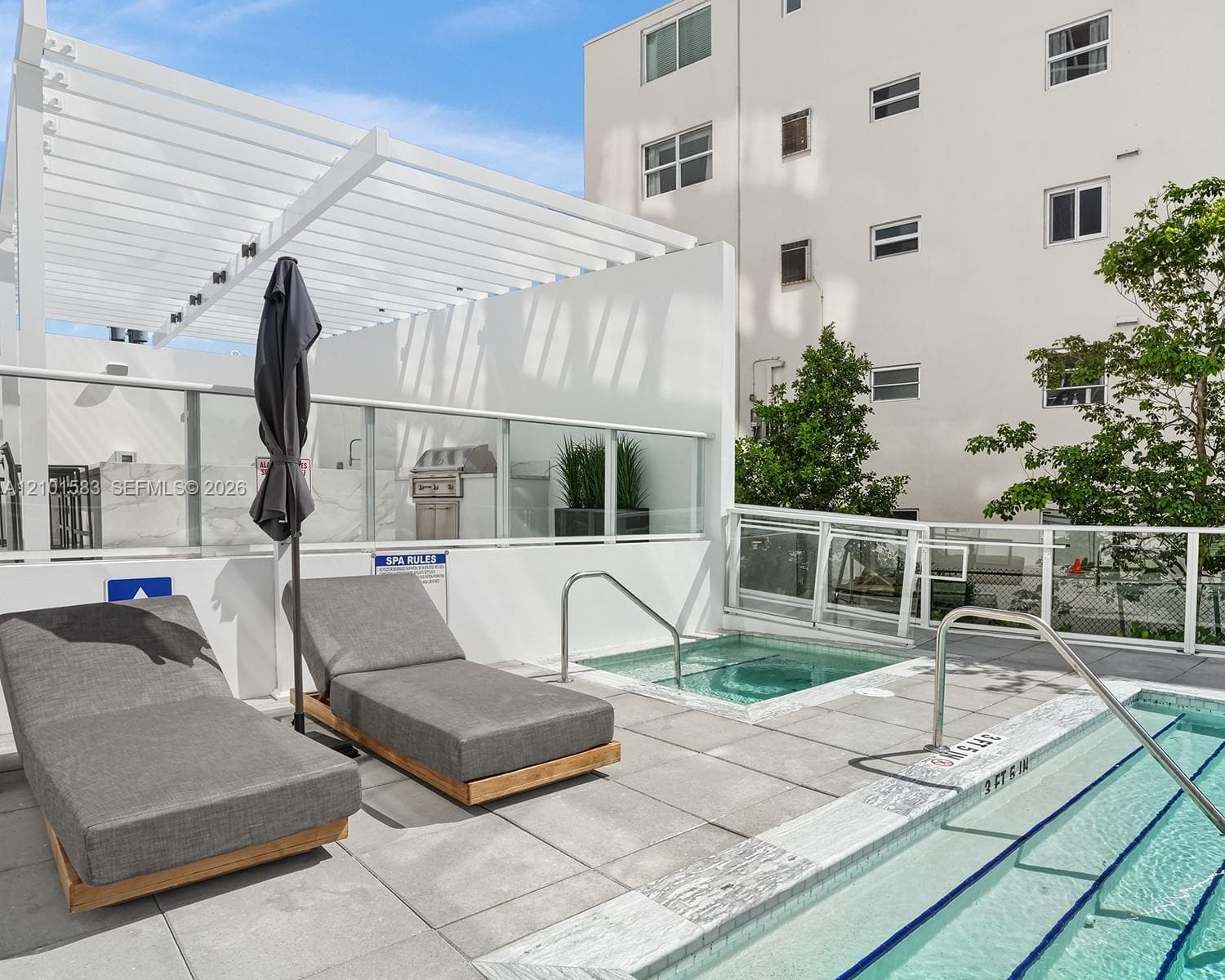 Rooftop terrace featuring a swimming pool, integrated spa, white aluminum pergola, built-in outdoor grill, and glass railing