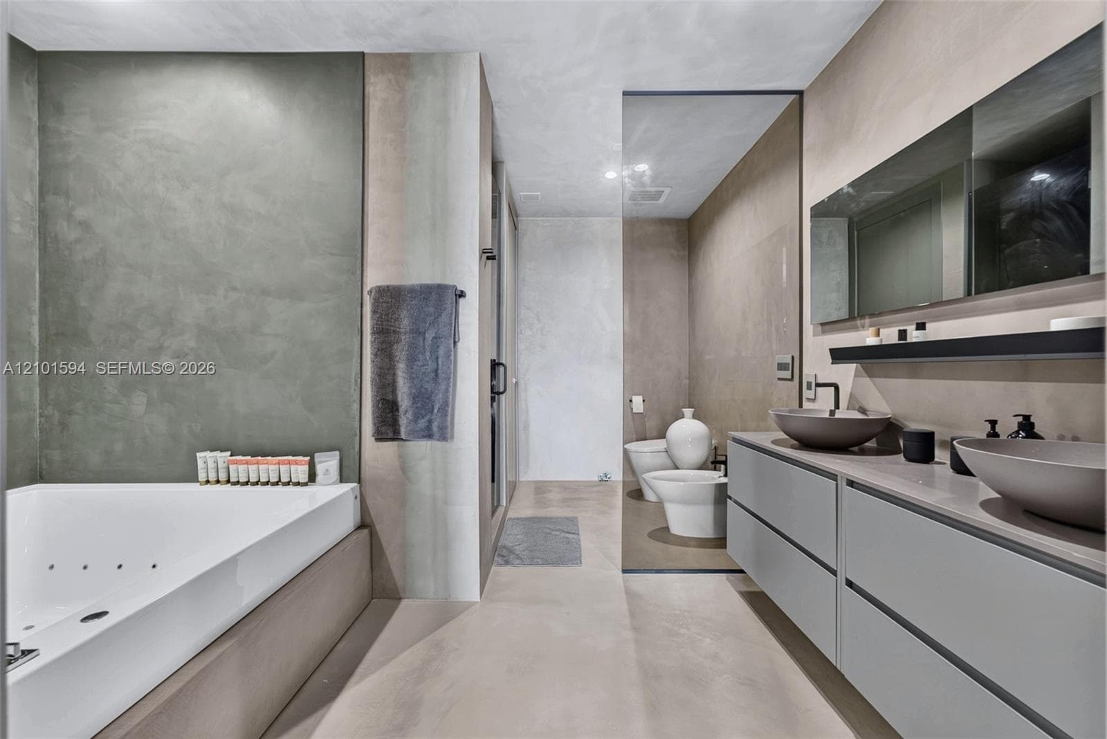 Primary bathroom with oversized spa tub, glass-enclosed shower and dual-sink vanity.