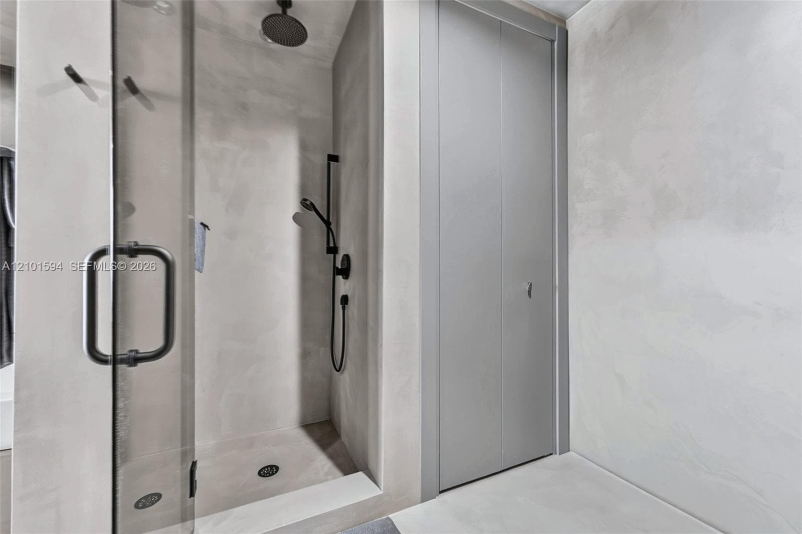 Bathroom with glass-enclosed shower and Hansgrohe thermostatic fixtures.
