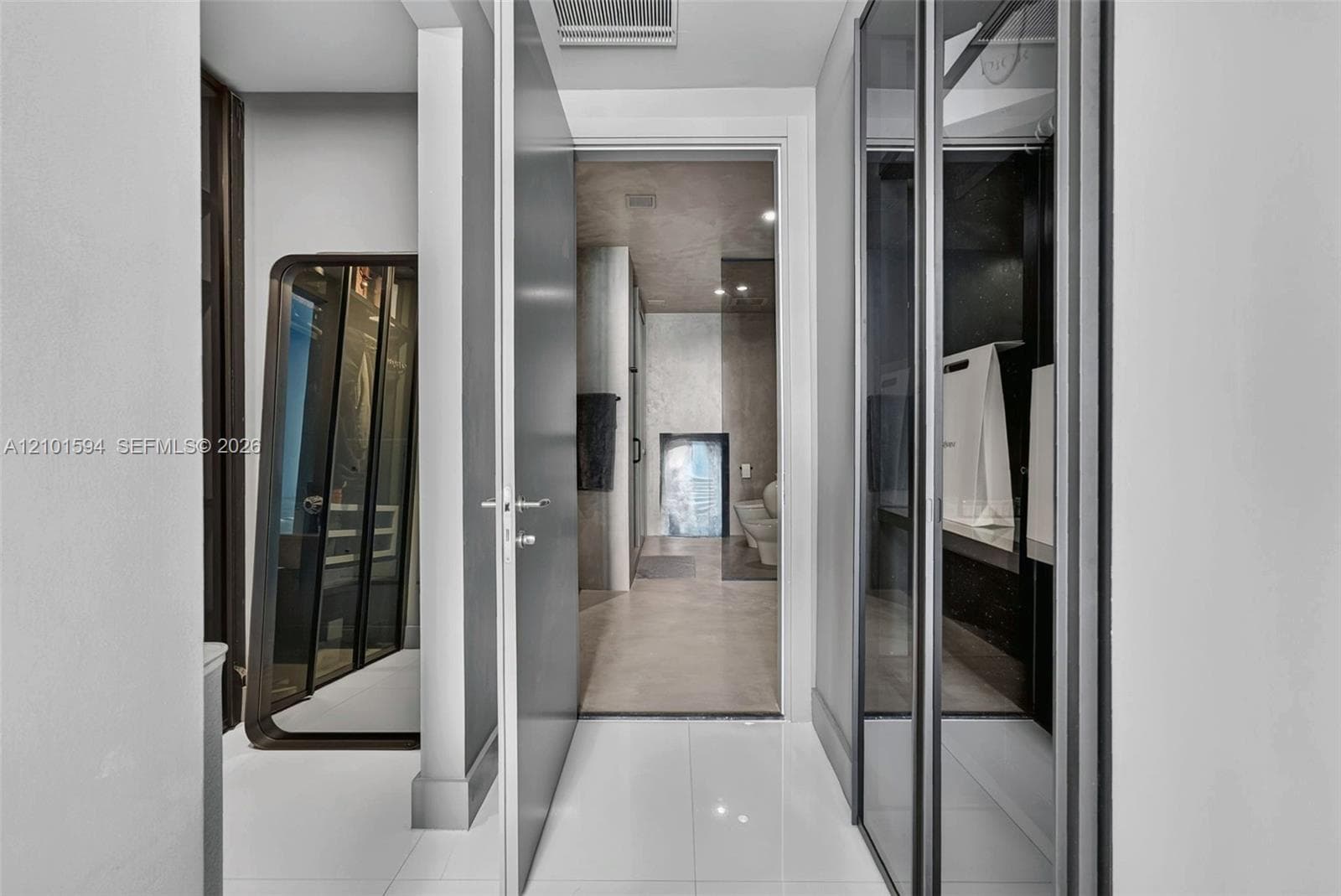 Primary suite hall with Sangiacomo glass-enclosed closets, leading to the primary bath.