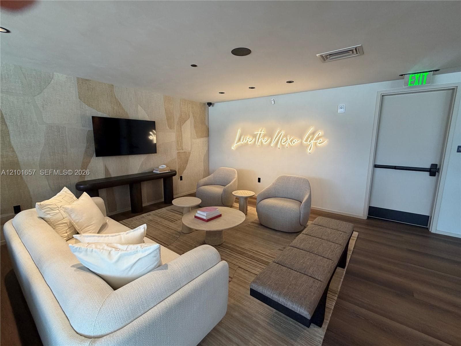 Recessed lighting, wood-finish flooring, and an accent wall featuring textured wallcovering