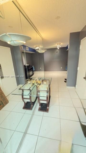 Large-format ceramic tile flooring, expansive wall-to-wall mirrored paneling, and multi-bulb flush-mount lighting fixtures