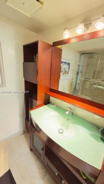 Custom wooden vanity with integrated shelving, frosted glass countertop, built-in mirror, and three-light vanity fixture