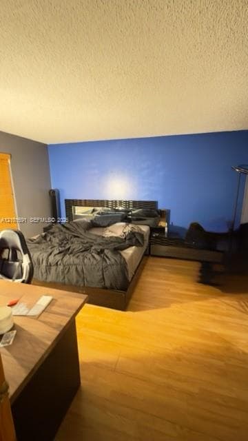 Wood-finish flooring and integrated built-in headboard cabinetry featuring mirrored accents